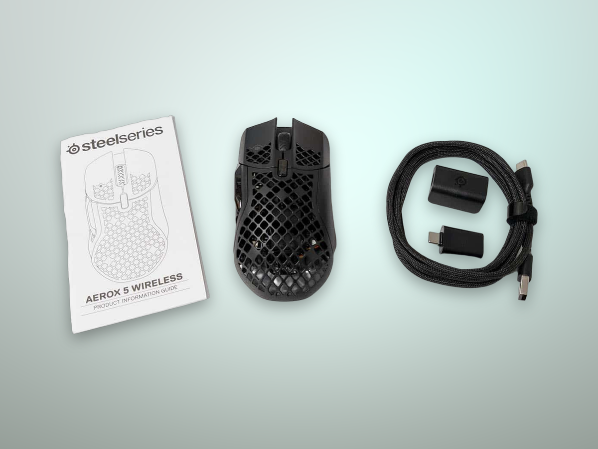 Confezione e accessori del SteelSeries Aerox 5 Wireless con dongle USB-C, adattatore di estensione e cavo intrecciato